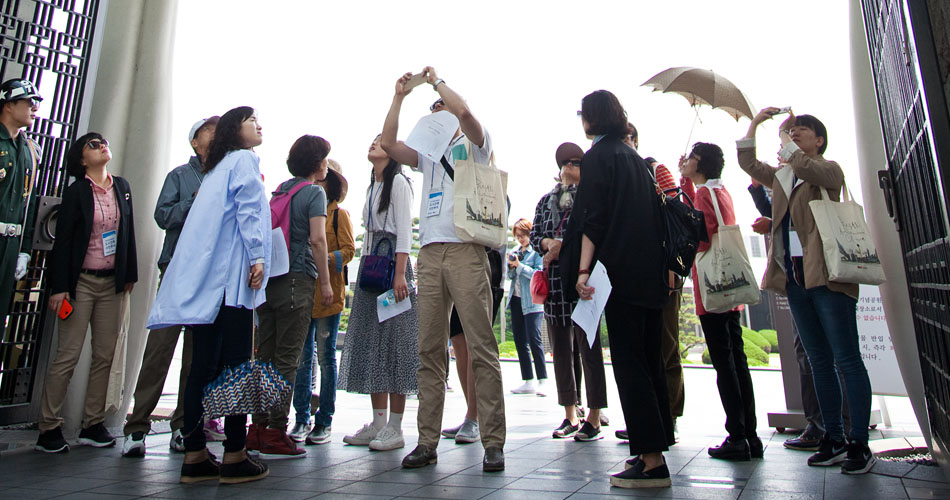 UN기념공원 정문의 독특한 형식을 느끼고 있는 참가자들의 모습.