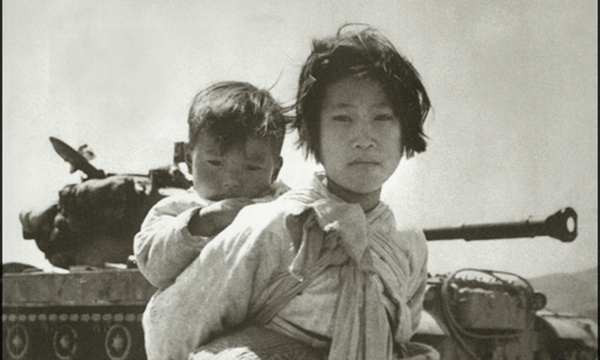 눈빛 출판사에서 펴낸 <한국전쟁> 표지 사진. 소녀가 아이를 업고 이쪽을 바라본다.  