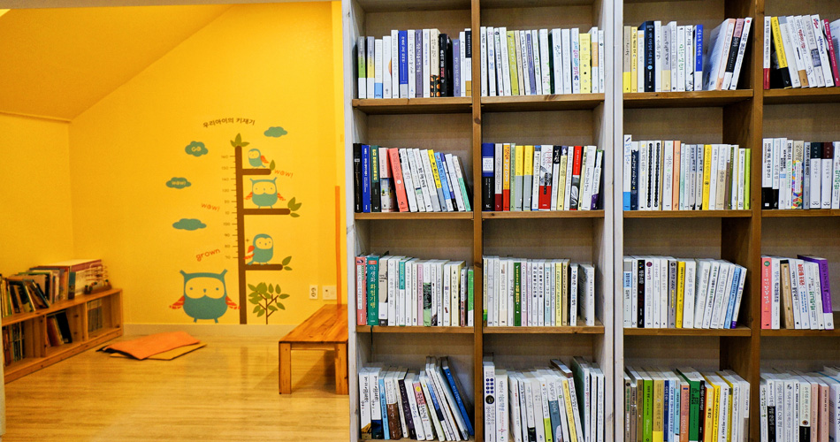 노란 벽에 마루바닥으로 이루어진 어린이방과 바로 옆 책 판매대
