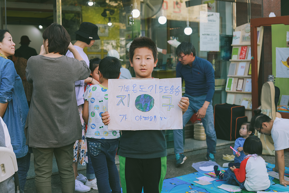 기후 위기를 경고하는 피켓을 들고 있는 어린이