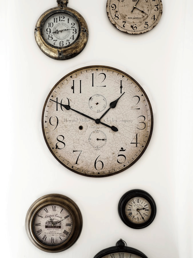 벽에 걸린 여러개의 로마숫자 시계들