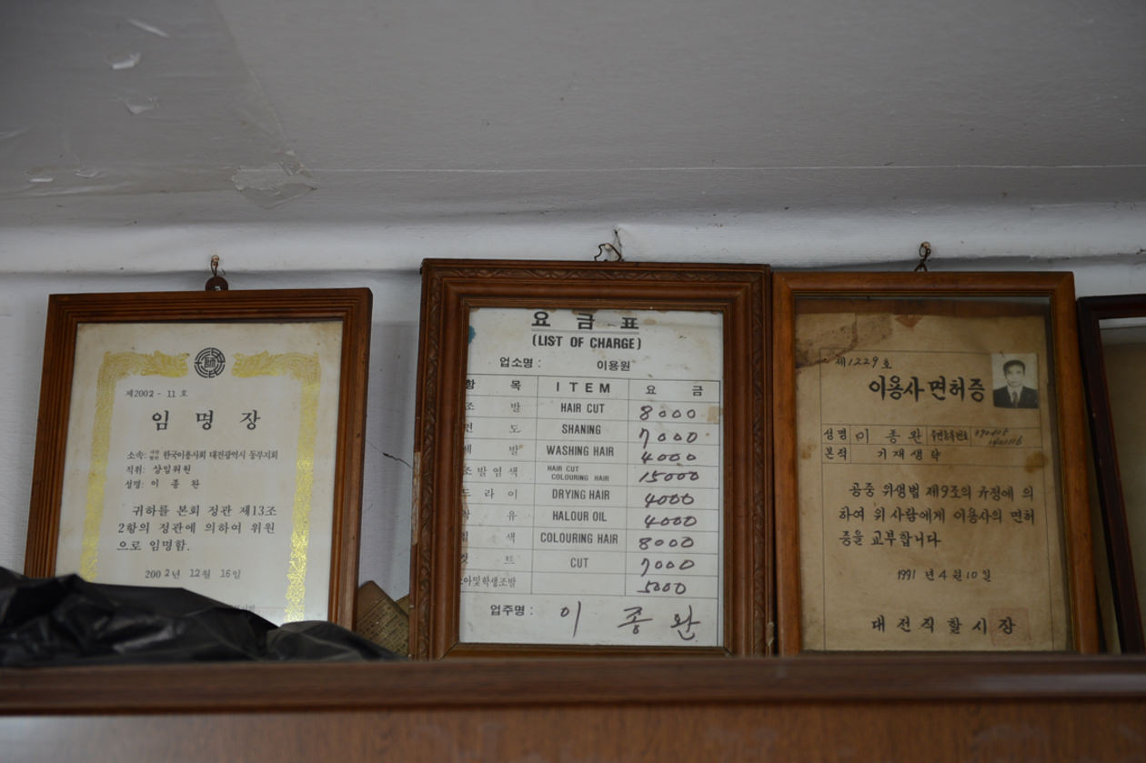 이발소 내 걸려있는 3가지의 액자 (왼)한국미용사회 상임위원 임명장, (중)이발요금, (오)이용자면허증