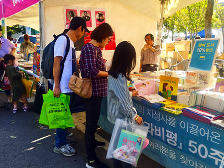 야외 북마켓에서 책을 구매하는 사람들