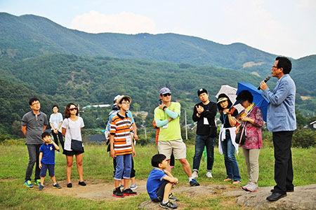 남연군묘앞에서 참가자들이 김두규 교수의 강의를 듣고 있다.