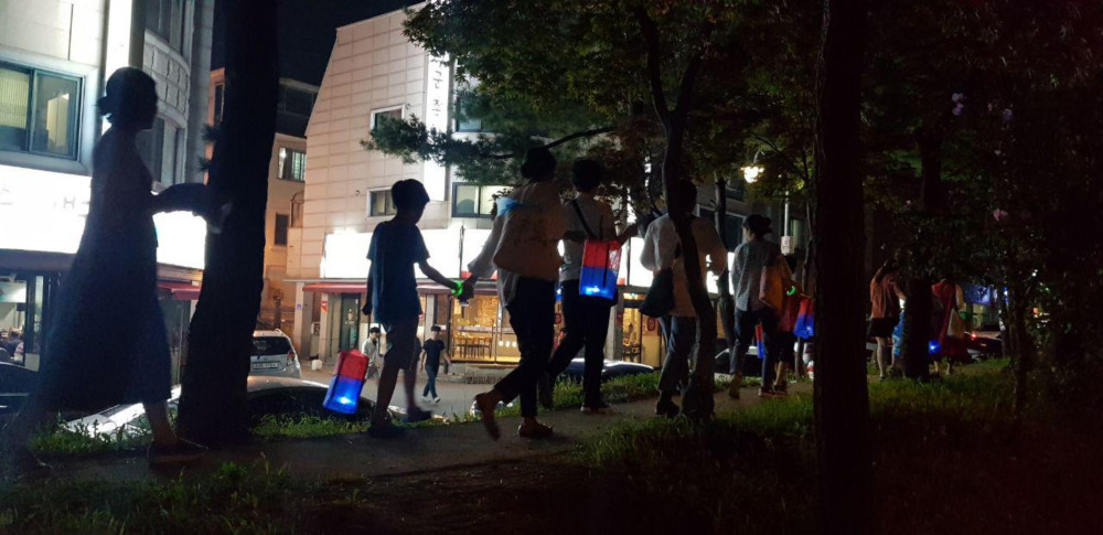 청사초롱으로 불밝히며 걸어가는 사람들 